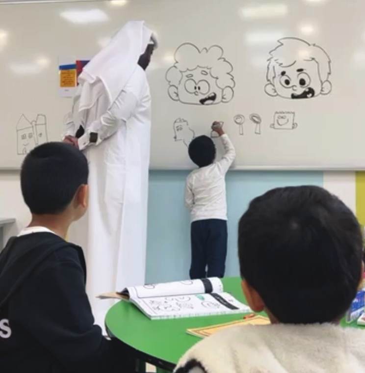 Children drawing on a wall during a school workshop